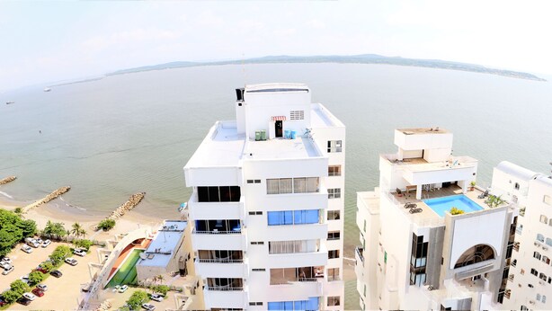 A high-rise hotel with multiple balconies overlooking a beach and the sea. - 2C19 Apartamento Cartagena frente al mar (Cartagena)