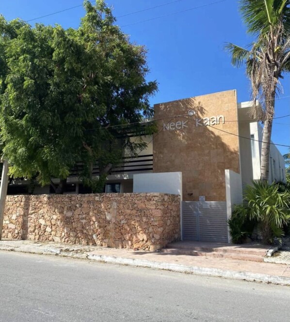 Un edificio con un muro de piedra y un letrero que dice "Neek Kasim".