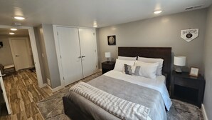 A bedroom with a bed, nightstands, a headboard, a door, and a wall with a logo. - Packer themed, renovated 3 bedroom, 2 1/2 bath home- Lambeau Field 16 min walk. (Green Bay)