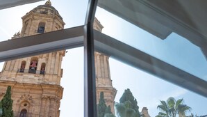 A view of a historic building with a bell tower through a window. - Bright apartment with views of the Cathedral (Málaga)