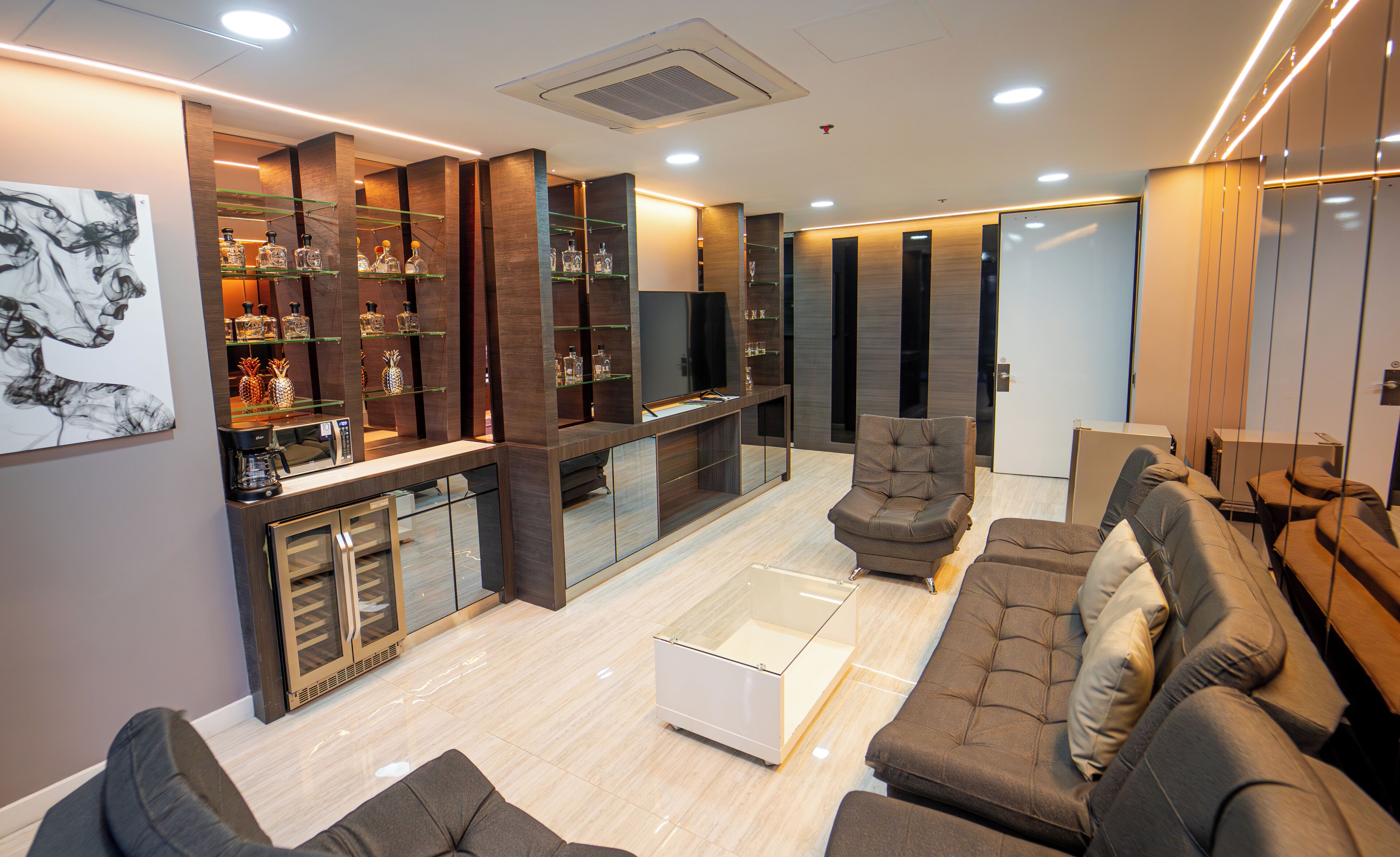 A modern living room with a sectional sofa, a coffee table, a TV, and a glass cabinet with decorative items.