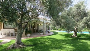 A well-maintained garden with a pergola, outdoor seating, and a swimming pool. - Rei Sole (REI308) by Interhome (Costa Rei)