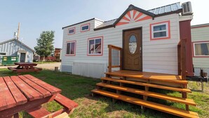 A small, single-story mobile home with a front porch and a picnic table. - Tiny House Martin - Pet Friendly (Leadville)