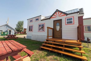 Simple, single-story home with a front porch and patio area.