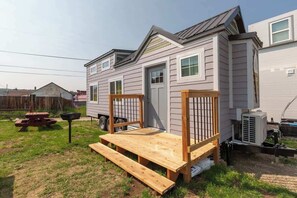 A mobile home with a small deck and a picnic table. - Tiny House Huckleberry - downtown & pet friendly (Leadville)