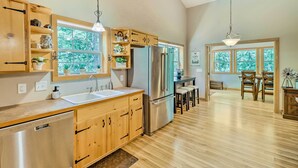 A modern kitchen with wooden cabinets, stainless steel appliances, and large windows. - Heber Springs Family Lake House: Fire Pit & Decks (Heber Springs)