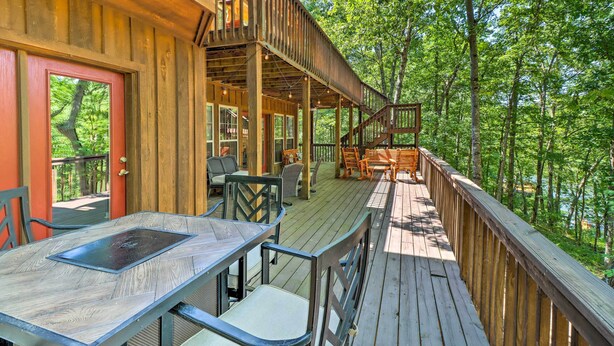 A wooden deck with outdoor seating and a view of a forested area. - Heber Springs Family Lake House: Fire Pit & Decks (Heber Springs)