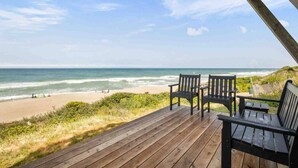 A wooden deck with two chairs overlooking a beach. - Boundless Ocean Views From Home and Hot Tub, Pet Friendly, Private Deck, Fireplace, Steps to Beach (Depoe Bay)