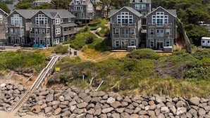 A coastal residential area with stone walls and houses with multiple stories and balconies. - Boundless Ocean Views From Home and Hot Tub, Pet Friendly, Private Deck, Fireplace, Steps to Beach (Depoe Bay)
