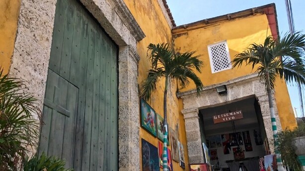 A building with a large wooden door, a sign reading "GEISEMANI VIVO," and several potted plants. - 2G2-2 Apartamento en la Ciudad Antigua (Cartagena)