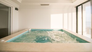 A spa room with a hot tub, large windows, and a ceiling vent. - Luxury 8 Bedroom Penthouse with Private Jacuzzi (Cartagena)