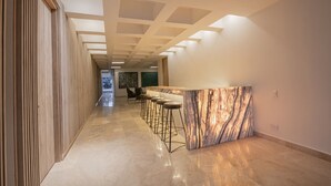 A modern interior with a marble bar and bar stools, a wooden slatted wall, and a clean, polished floor. - 7 Bedroom Luxury Full Floor Apartment with Private Pool (Cartagena)