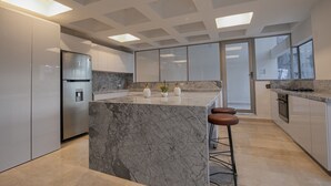 A modern kitchen with a marble island, stainless steel appliances, and a large window providing natural light. - 7 Bedroom Luxury Full Floor Apartment with Private Pool (Cartagena)