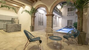 Un espacio interior amplio con cocina, zona de estar y piscina.