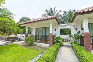 A two-story house with a tiled roof, large windows, and a well-maintained garden.