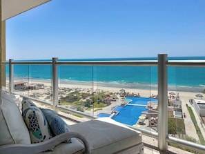 Ein Balkon mit Blick auf Strand und Poolbereich.