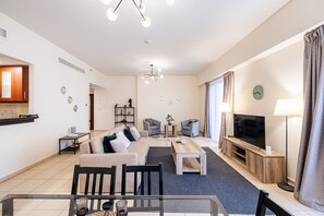 A modern living room with a sofa, coffee table, TV, and seating area. - 3 Minute Walk to Beach 1 Bed Rimal 3 JBR (Dubai)