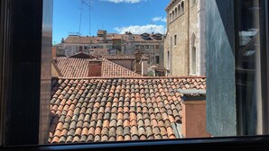 A view of terracotta-tiled rooftops and a stone building with arched windows. - Apartment, A stone's throw from St. Mark's with a lovely view  (Venezia)