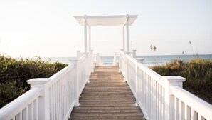 A wooden pathway leading to a white pergola with a view of the ocean. - Single level, Interior home with Private Pool and Golf Cart in Spinnaker's Reach (Emerald Isle)