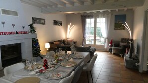 A dining area with a table set for a meal, a fireplace, and a Christmas tree. - VILLA FOUILLEBROC with swimming pool (Touffreville)
