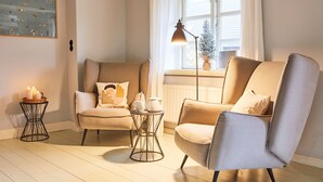 A cozy living room with two armchairs, a small side table, and a floor lamp.