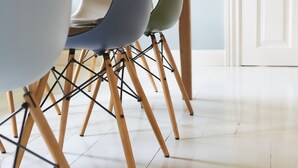 A dining area with a wooden table and chairs with wooden legs.