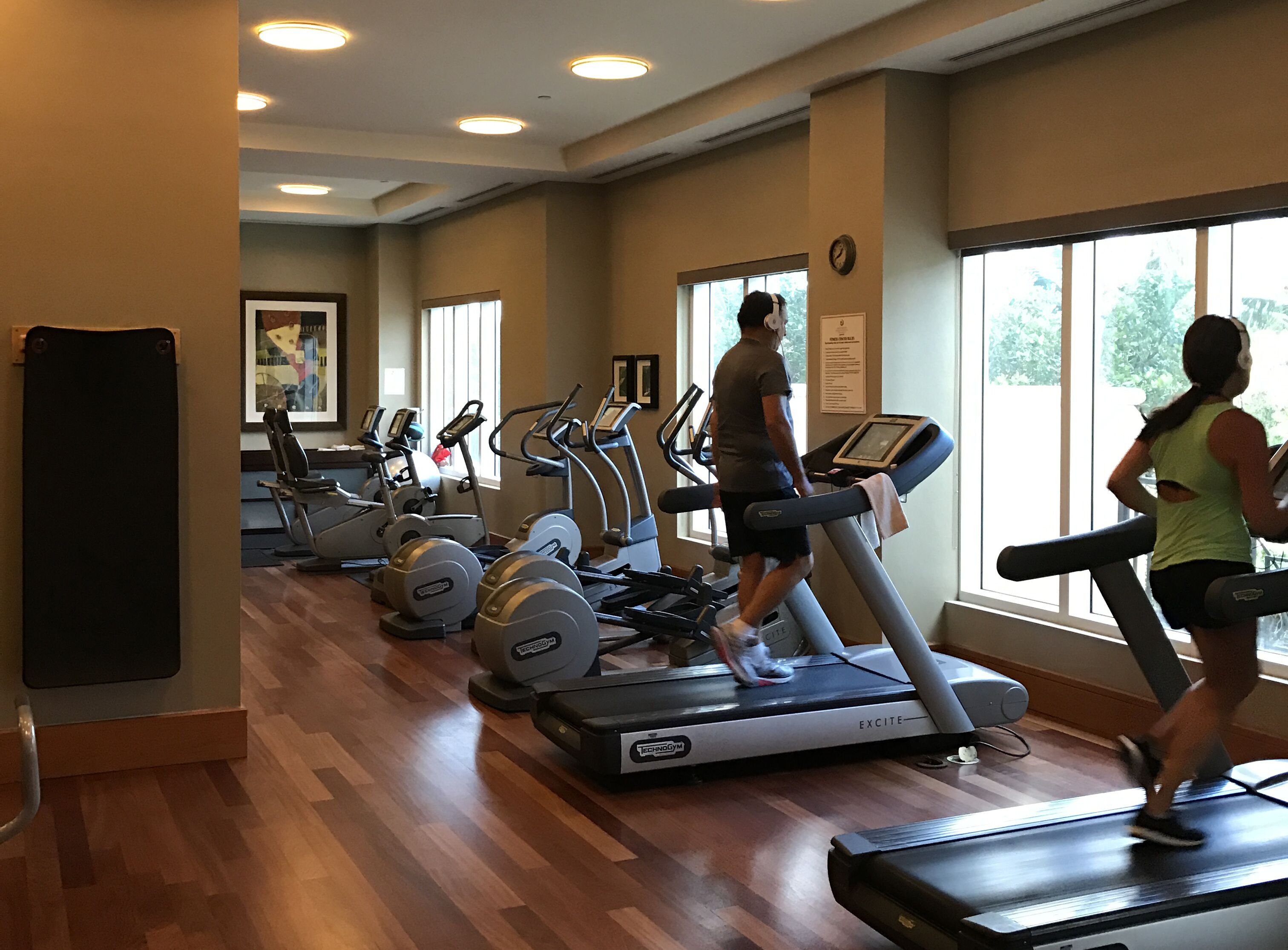 Un gimnasio equipado con cintas de correr, elípticas y bicicletas estáticas.