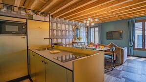 Eine Küche mit Einbau-Mikrowelle, Spüle und Essbereich inklusive Tisch und Stühlen.