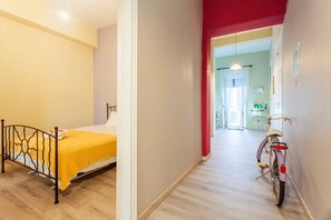 Una camera da letto con un letto, una bicicletta e un corridoio che porta al bagno.