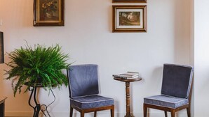 A room with two chairs, a small round table with books, and a potted plant. - Le Fonti - Monteloro, large and bright (Pontassieve)