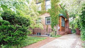 A brick building with ivy-covered walls and a gated entrance. - FAMILY-FRIENDLY / SUBWAY / ROOFTOP DECK / AU (Washington)