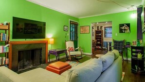 A living room with a fireplace, green walls, a sofa, and a bookshelf. - FAMILY-FRIENDLY / SUBWAY / ROOFTOP DECK / AU (Washington)