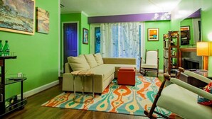 A living room with a sofa, a chair, a small table, and a bookshelf. - FAMILY-FRIENDLY / SUBWAY / ROOFTOP DECK / AU (Washington)