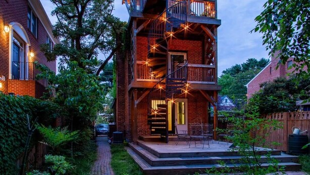 A multi-story building with a spiral staircase, outdoor seating, and a brick facade. - FAMILY-FRIENDLY / SUBWAY / ROOFTOP DECK / AU (Washington)