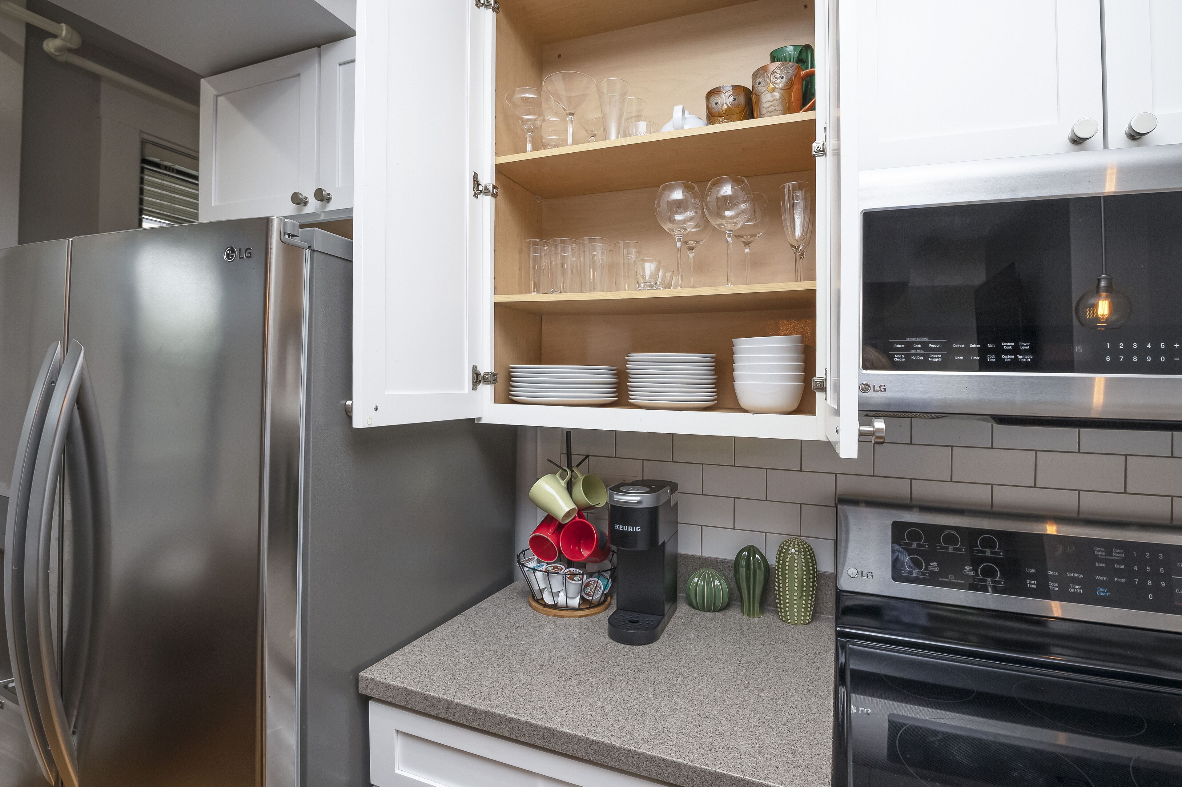 Eine Küche mit Edelstahl-Kühlschrank, Mikrowelle und Kaffeemaschine auf der Arbeitsplatte.