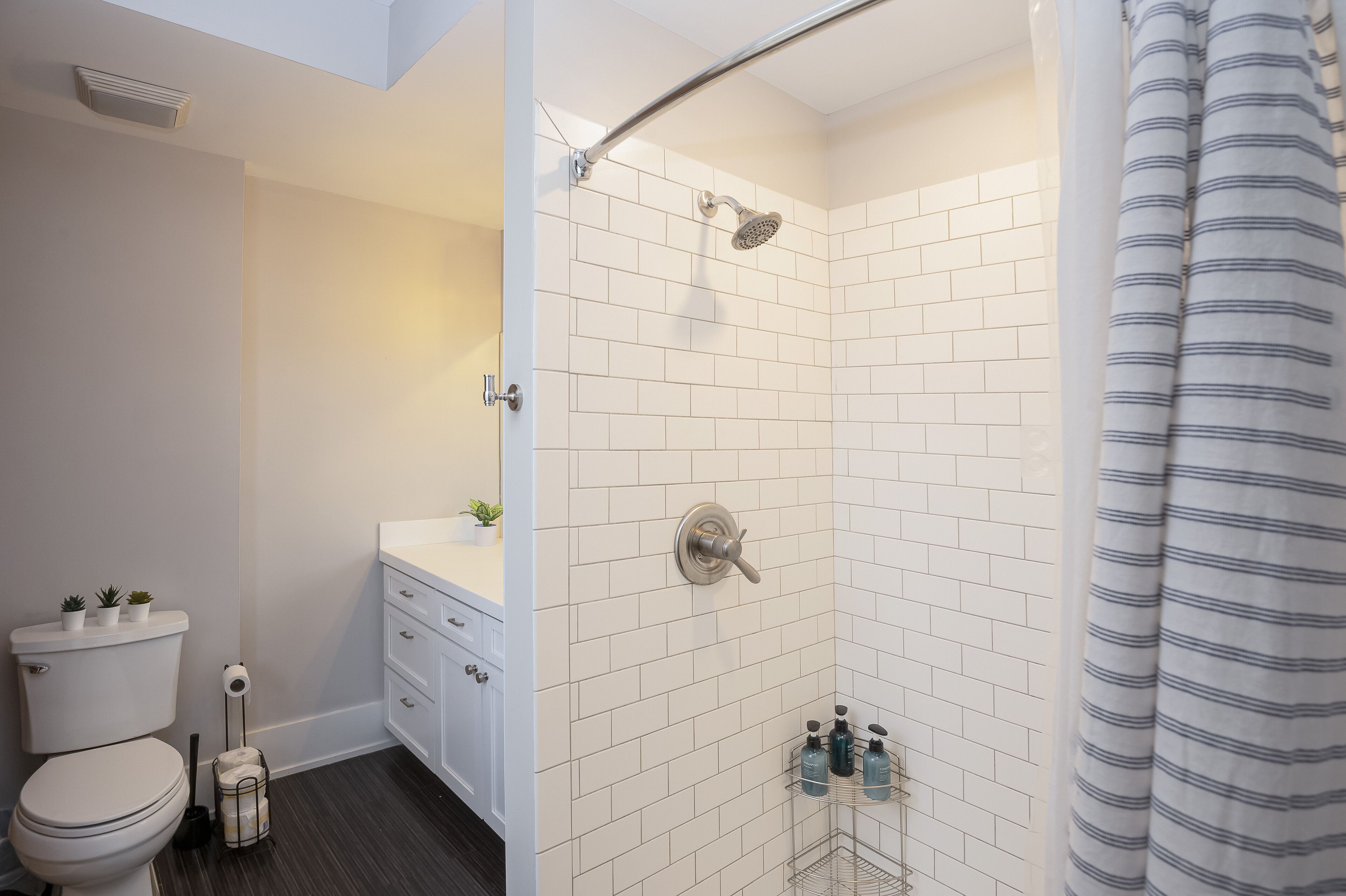 Une salle de bain moderne équipée d’une douche, de toilettes et d’un lavabo.