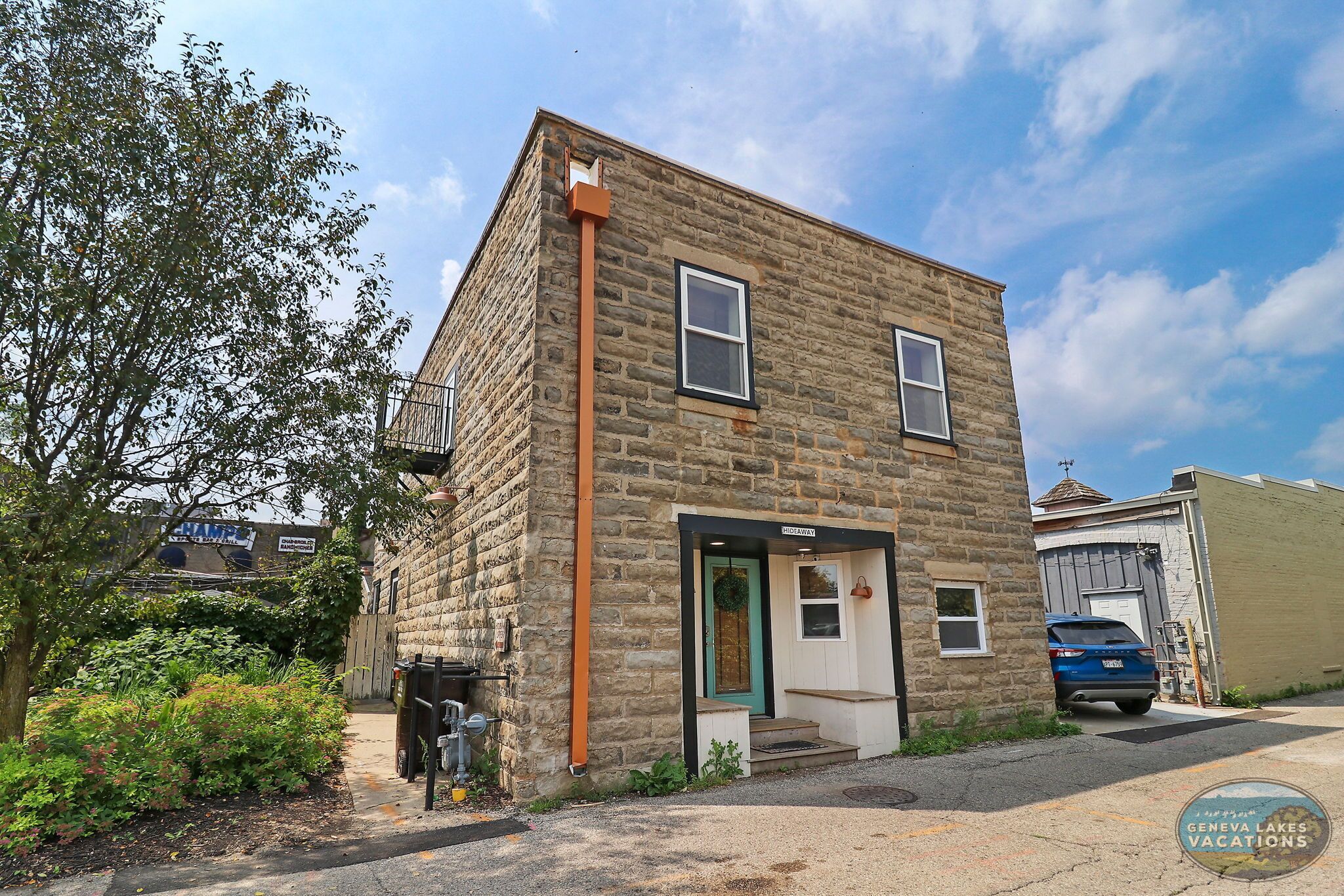 A stone building with a small porch and a garage door.