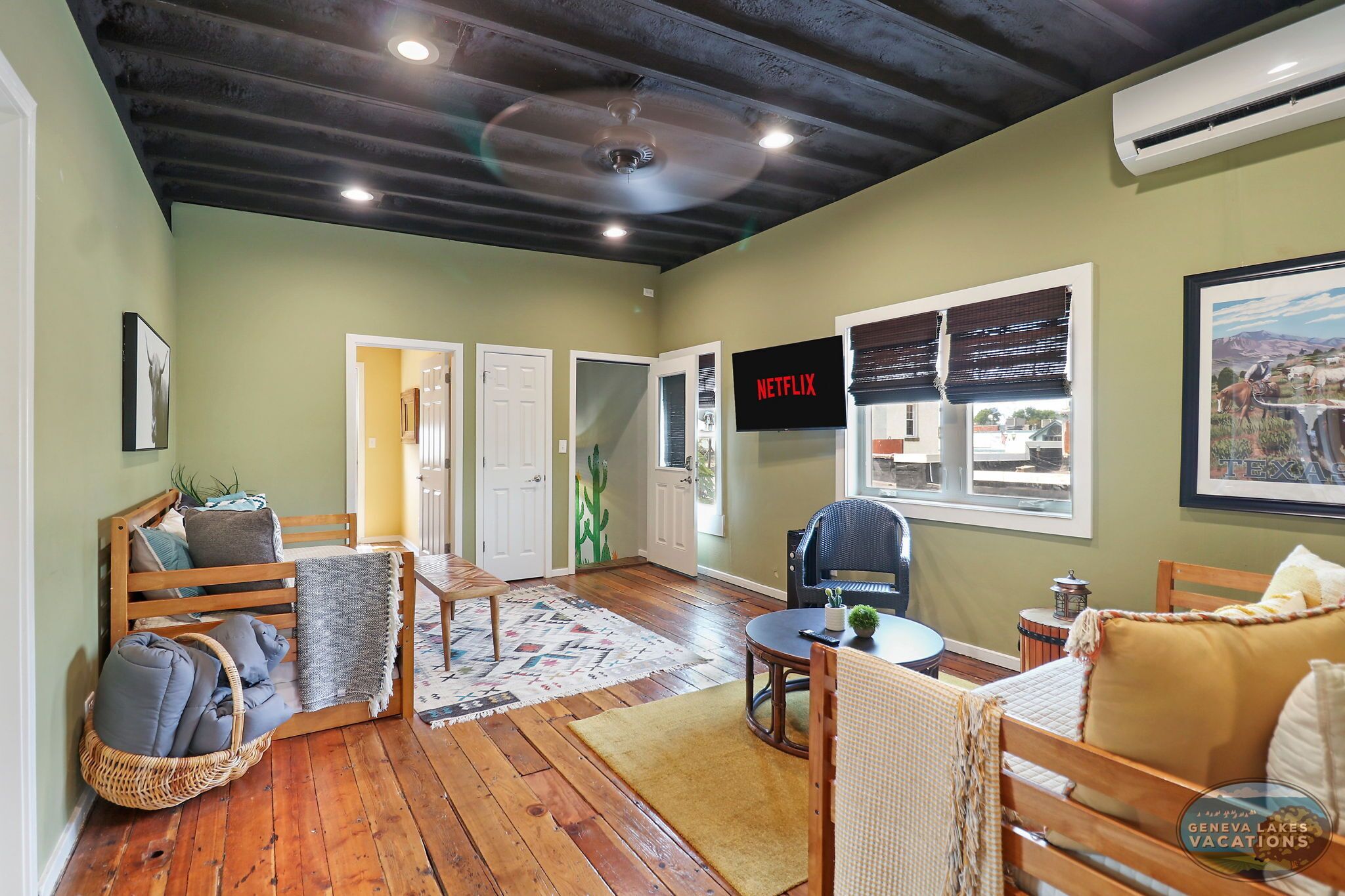 A cozy living room with a wooden bench, a small table, and a TV displaying 'NETFLIX'.