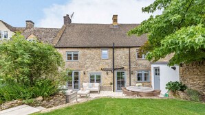 A stone house with a front yard, a patio with seating, and a small garden area. - A luxury holiday cottage in the Cotswolds - Manor Farm Cottage (Donnington, near Stow-on-the-Wold)