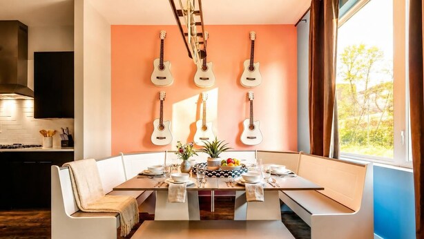 A modern dining area with a built-in bench seating, a central table, and guitars mounted on the wall.