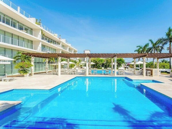 Alberca al aire libre y camastros 