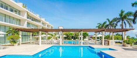 Een buitenzwembad, ligstoelen bij het zwembad