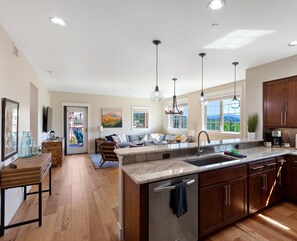 Una cocina amplia con una isla grande, armarios de madera y vistas al exterior.