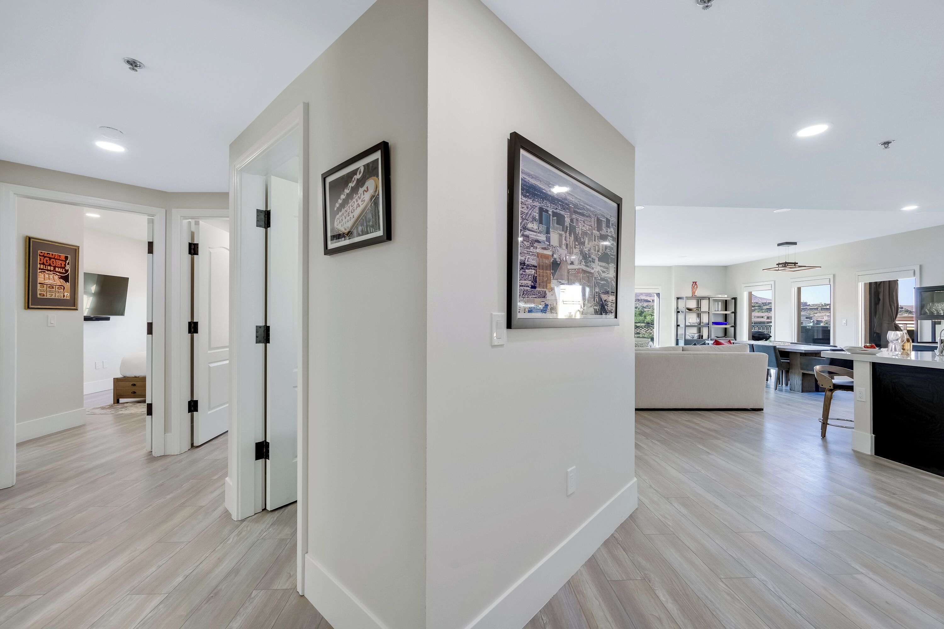 A modern kitchen with a large island, white cabinetry, and a view of the cityscape through the windows.