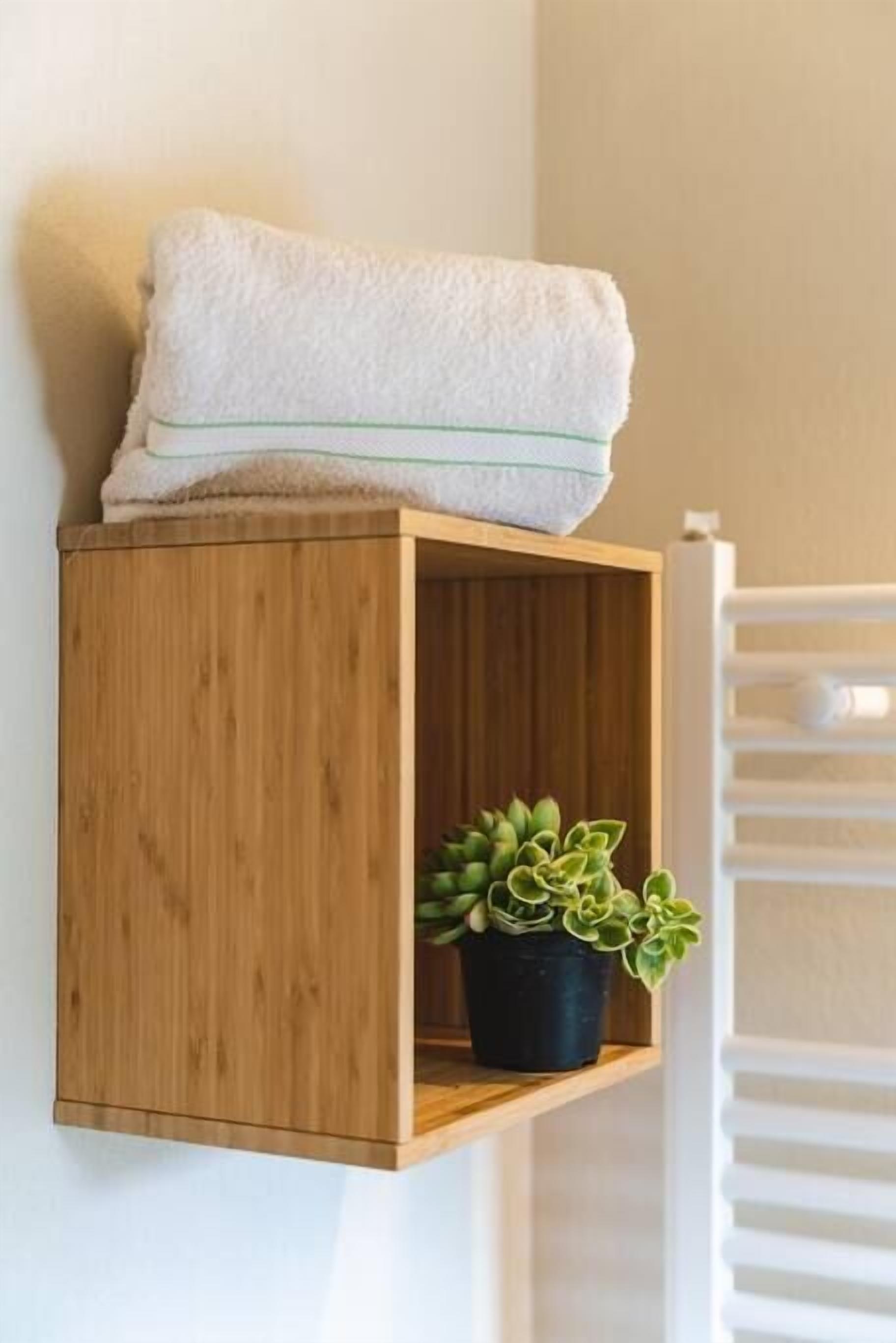 Een houten plank met een witte handdoek en een vetplant in pot.