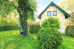 A house with a green roof and a well-maintained garden. - Vacation home Wolfgram with terrace and barbecue facilities - Ferienhaus Wolfgram (Trassenheide)
