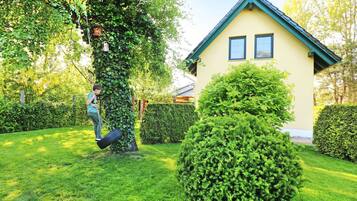 Ein Haus mit einem grünen Dach und einem gepflegten Garten.