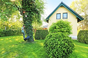 Ein Haus mit einem grünen Dach und einem gepflegten Garten.