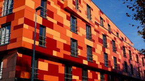 A modern building with a geometric facade and multiple windows. - Havenhostel Stade GmbH - Double room (Stade)