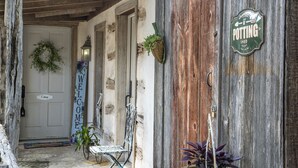 A rustic wooden building with a 'Welcome' sign, a 'Potting Shed' sign, and a bicycle. - Wildflower Cottage/PERFECT LOCATION!!/Walk to Main/Marktplatz!! (Fredericksburg)